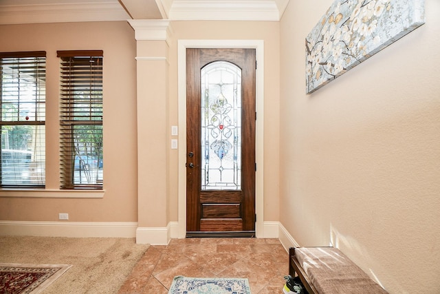 carpeted entrance foyer with crown molding and baseboards