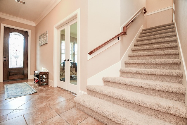 foyer entrance with visible vents, french doors, stairway, and ornamental molding