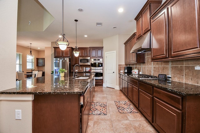 kitchen with visible vents, a sink, under cabinet range hood, backsplash, and appliances with stainless steel finishes