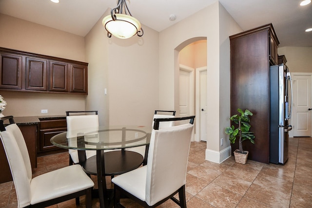 dining room with recessed lighting, baseboards, and arched walkways