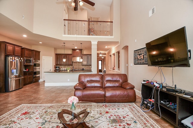 living area with visible vents, recessed lighting, arched walkways, baseboards, and ceiling fan