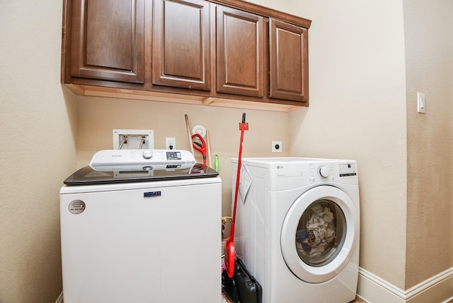 laundry area featuring cabinet space, baseboards, and washer and clothes dryer