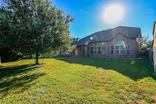 exterior space with a lawn, fence private yard, and brick siding