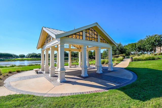 view of property's community with a gazebo, a yard, a water view, and a patio