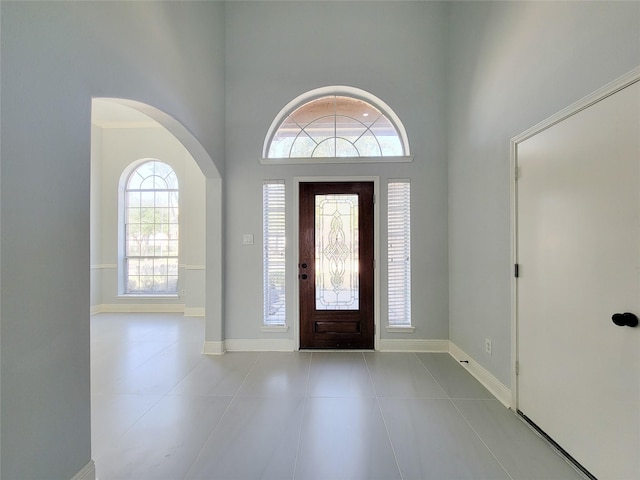 tiled entryway featuring a towering ceiling