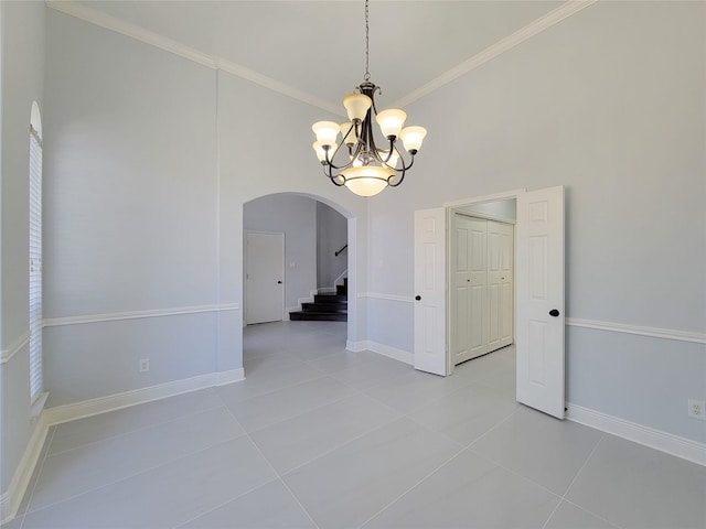 empty room featuring a notable chandelier, light tile patterned flooring, and crown molding