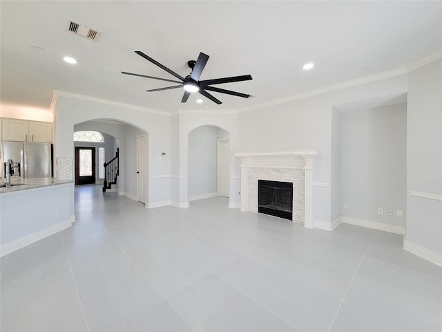 unfurnished living room featuring ornamental molding, ceiling fan, and light tile patterned floors