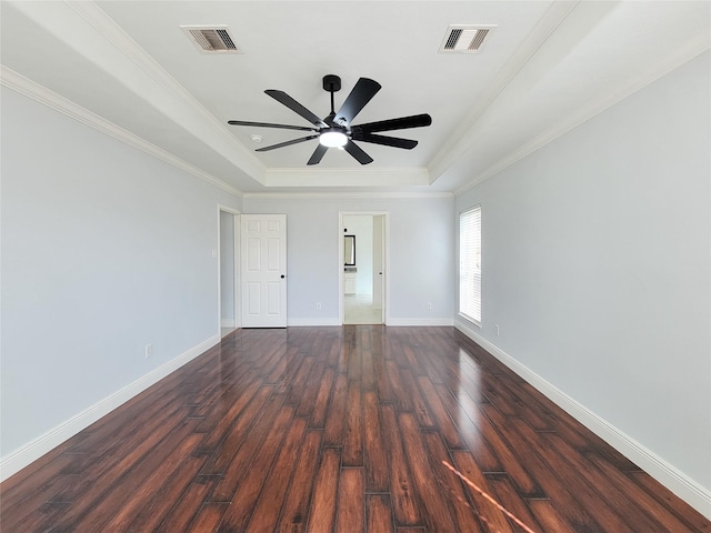 unfurnished bedroom featuring a tray ceiling, ceiling fan, crown molding, and dark hardwood / wood-style floors