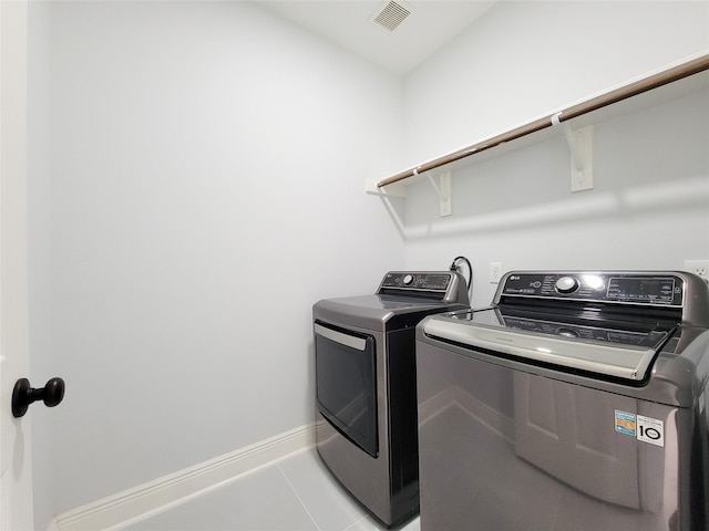 laundry area featuring light tile patterned flooring and separate washer and dryer