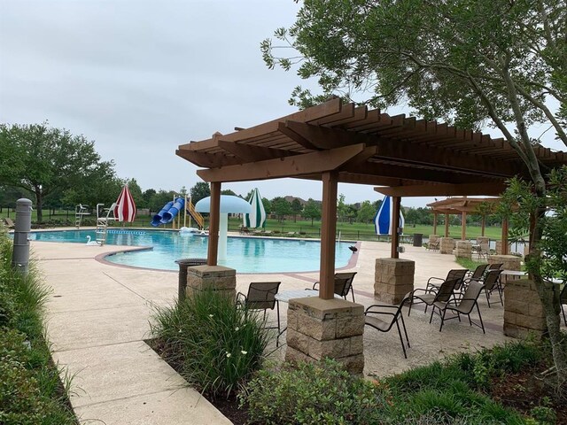 view of swimming pool featuring a pergola, a patio area, and a water slide