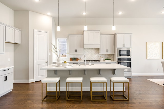 kitchen featuring stainless steel appliances, light countertops, dark wood-type flooring, and tasteful backsplash