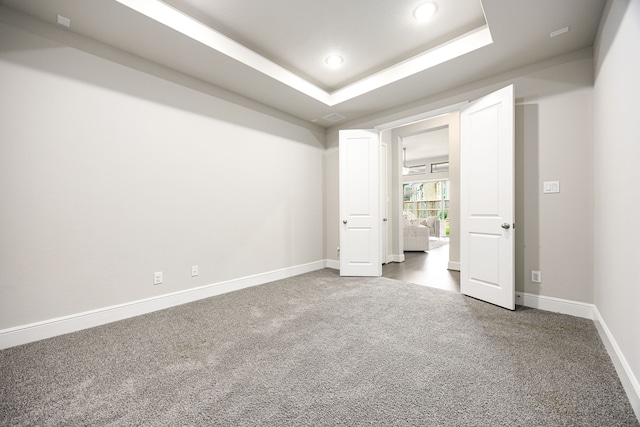 interior space featuring baseboards, visible vents, a tray ceiling, carpet flooring, and recessed lighting