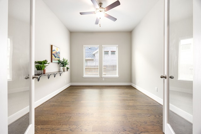 unfurnished room with baseboards, a ceiling fan, and wood finished floors