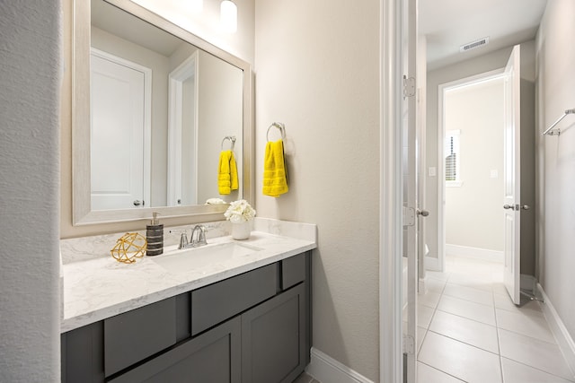 bathroom with baseboards, vanity, visible vents, and tile patterned floors