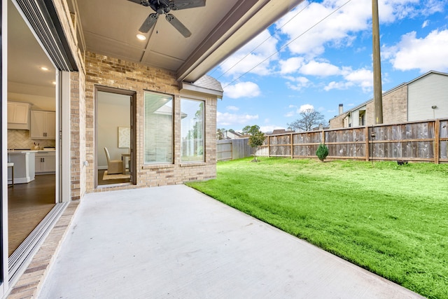 view of yard featuring a patio area, ceiling fan, and a fenced backyard