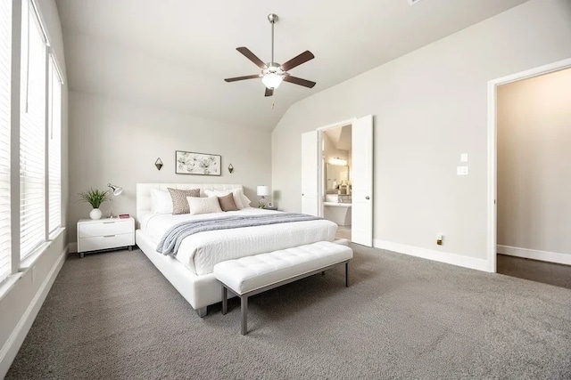 carpeted bedroom featuring ceiling fan, ensuite bath, baseboards, and vaulted ceiling