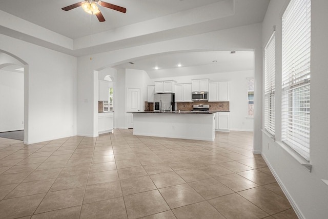 114 Kohen Ct, Montgomery, TX 77316 - unfurnished living room featuring light tile patterned flooring, a ceiling fan, and arched walkways