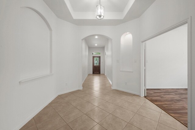 114 Kohen Ct, Montgomery, TX 77316 - corridor featuring arched walkways, light tile patterned floors, a raised ceiling, and baseboards