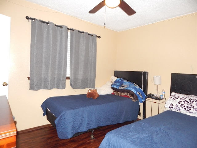 bedroom featuring ceiling fan, a textured ceiling, and dark hardwood / wood-style flooring