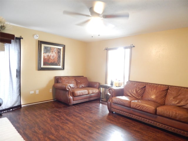 living room featuring dark wood-type flooring and ceiling fan