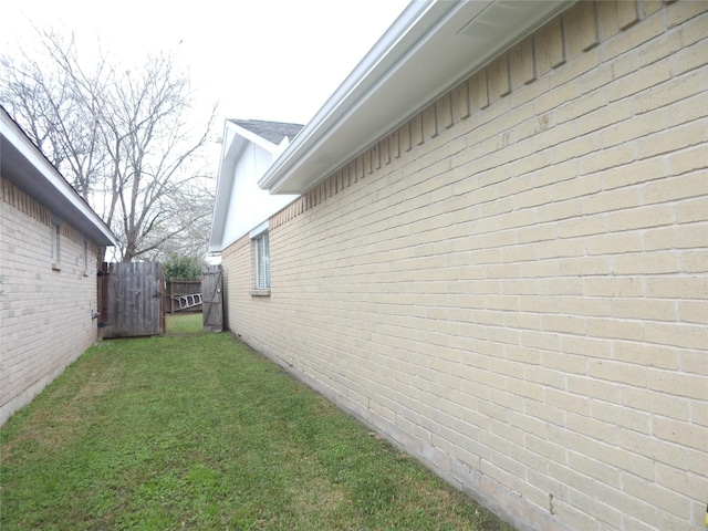 view of side of home with a yard