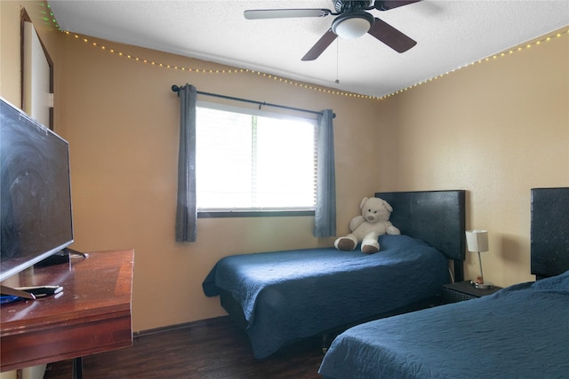 bedroom featuring a ceiling fan, wood finished floors, and a textured ceiling