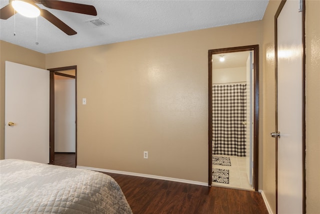 bedroom featuring dark wood-type flooring, baseboards, a textured ceiling, and visible vents