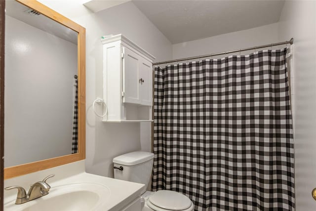 bathroom with toilet, vanity, curtained shower, and a textured ceiling