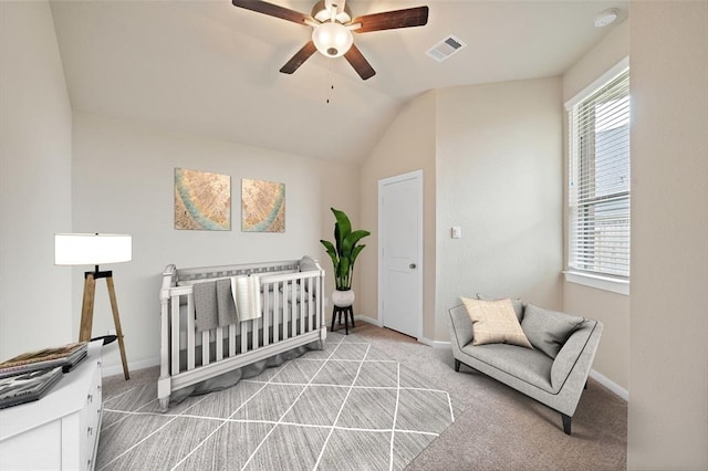 bedroom featuring a nursery area, light colored carpet, lofted ceiling, and ceiling fan