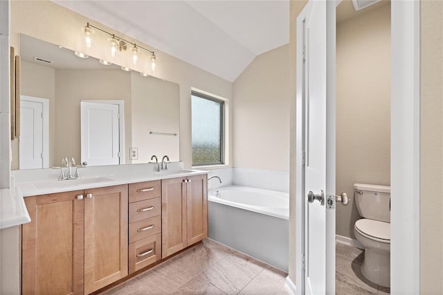 bathroom featuring lofted ceiling, vanity, tile patterned floors, a tub, and toilet