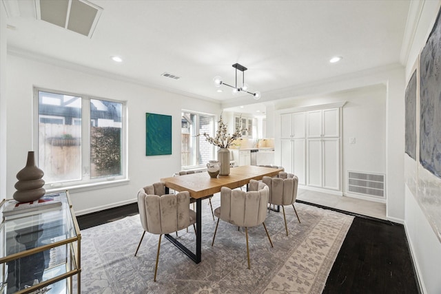 dining space featuring ornamental molding, dark wood-type flooring, and an inviting chandelier