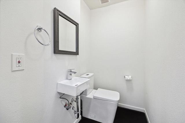 bathroom featuring toilet and sink