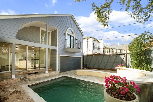 back of house with a garage and a balcony