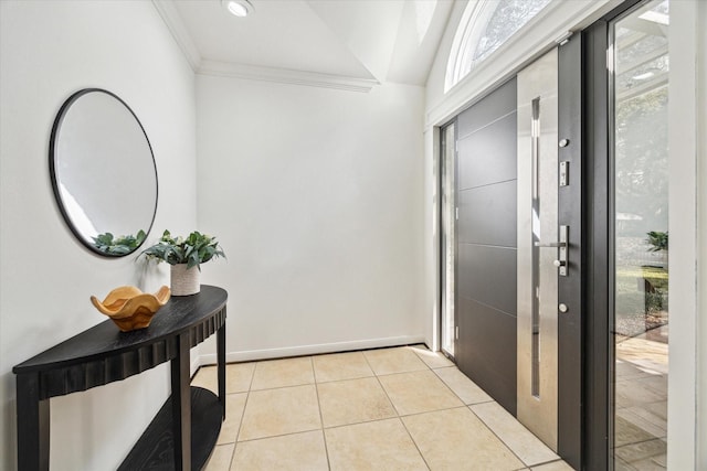 foyer entrance with crown molding and light tile patterned floors