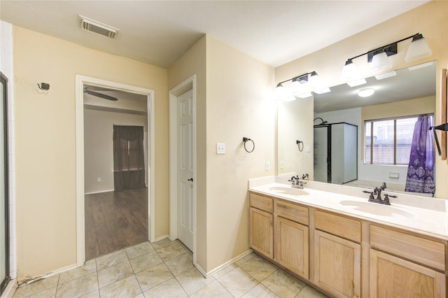 bathroom featuring vanity, a shower with shower door, and tile patterned floors