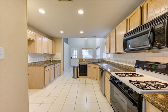 kitchen featuring dishwasher, sink, light tile patterned floors, gas stove, and light brown cabinets