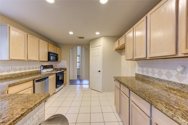 kitchen featuring white range with gas cooktop, light stone counters, and light brown cabinets