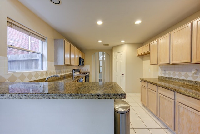 kitchen featuring stone countertops, light brown cabinets, and black appliances