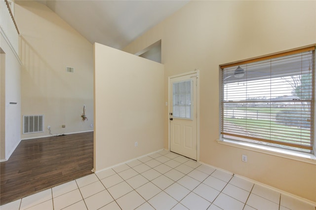 tiled foyer entrance with high vaulted ceiling