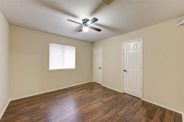 spare room featuring ceiling fan, dark hardwood / wood-style floors, and a textured ceiling