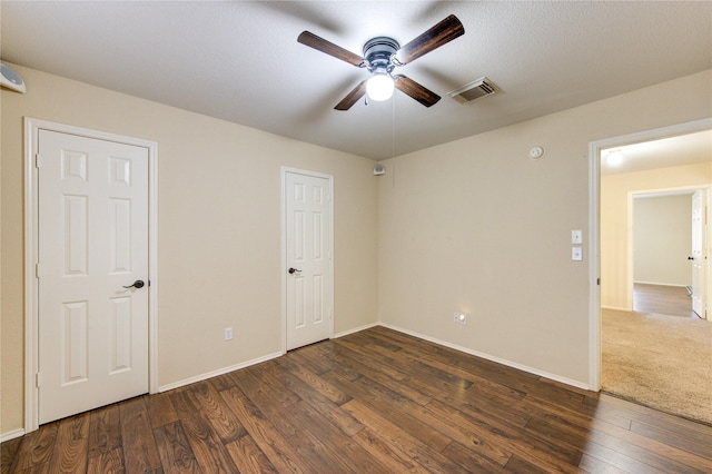 unfurnished room featuring dark wood-type flooring and ceiling fan