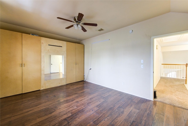 unfurnished bedroom featuring vaulted ceiling, dark hardwood / wood-style floors, and ceiling fan