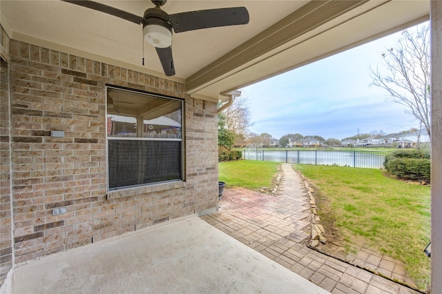 view of patio / terrace featuring a water view and ceiling fan