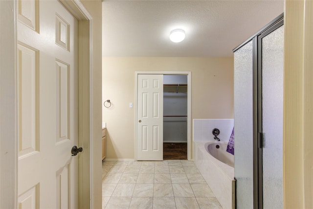 bathroom with vanity, tiled bath, and a textured ceiling