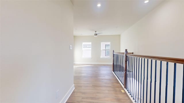 hallway featuring recessed lighting, baseboards, and light wood finished floors