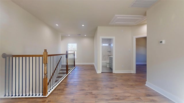 corridor featuring recessed lighting, visible vents, an upstairs landing, wood finished floors, and baseboards