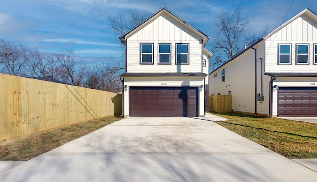 view of front of home with a garage, fence, board and batten siding, and a front yard