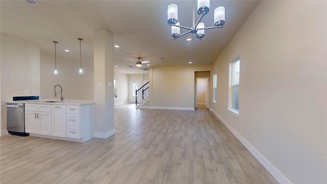 kitchen featuring open floor plan, stainless steel dishwasher, white cabinetry, and pendant lighting