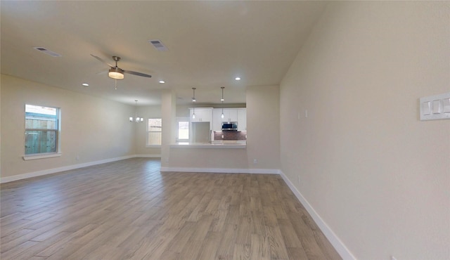 unfurnished living room featuring baseboards, visible vents, a ceiling fan, light wood-type flooring, and recessed lighting