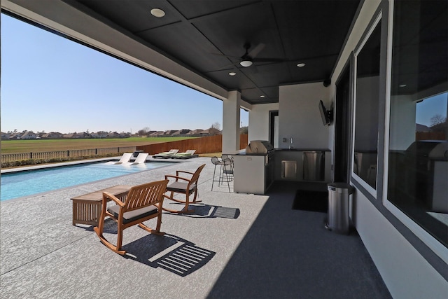 view of patio / terrace featuring ceiling fan, an outdoor kitchen, a fenced backyard, outdoor dry bar, and a fenced in pool